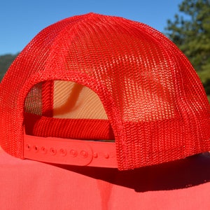 Op de afbeelding: Rode mesh trucker cap met een verstelbare plastic band. De pet is gemaakt van ademend mesh materiaal en heeft een klassieke trucker cap stijl.