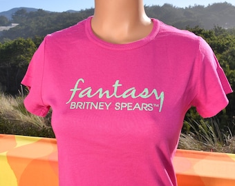 May include: Pink t-shirt with a green "fantasy" graphic and the text "Britney Spears" underneath.