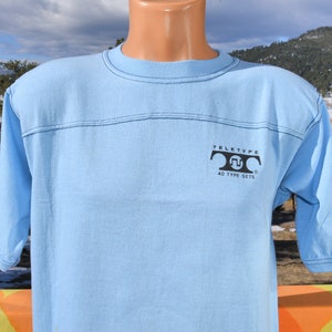 May include: Light blue t-shirt with a black Teletype logo and the text "40 Type Sets".