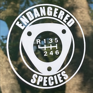 May include: White sticker with black text that reads "Endangered Species" and a white gear shift pattern with the numbers 1, 3, 5, 2, 4, and 6.