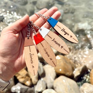 Personalisierte Surf-Schlüsselanhänger mit Gravur von Name, Datum oder Botschaft. Ein individuelles Geschenk für Surfer, Reisende und Meeresliebhaber.
