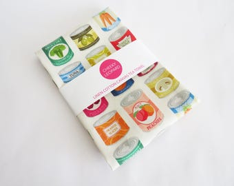 Paño de cocina con estampado vintage de latas de comida, confeccionado en tela de lino y algodón.