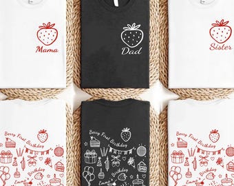 May include: White and black t-shirts with red strawberry designs. Some shirts have the words "Mama", "Dad", and "Sister". Other shirts have a strawberry and the text "Berry First Birthday" with birthday-themed illustrations.