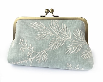 Pochette in lino ricamato con manico a catena opzionale.