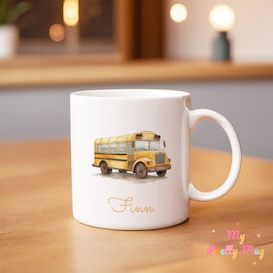 May include: White ceramic mug with a yellow school bus illustration and the name "Finn" in gold lettering.