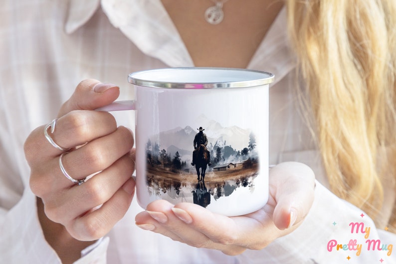 Woman holding a Cowboy enamel camping mug with a colorful Western design in her hands