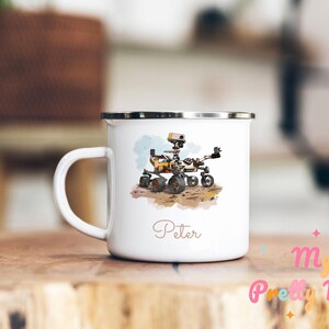 Peut inclure: Mug de camping en émail blanc avec une illustration aquarelle du rover martien Perseverance. Le mug a une bordure et une poignée argentées et le nom "Peter" est imprimé au bas.