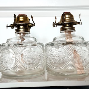 Pair of Vintage Lamplight Farms Glass Oil Lamps | Embossed Pioneer Scene | Hexagon Base | Brass Burner | Farmhouse Decor | Collectible Scene