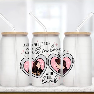 May include: Three frosted glass tumblers with bamboo lids and clear straws. The center tumbler features a pink heart design with two silhouettes and the text "AND SO THE LION fell in love with the lamb."
