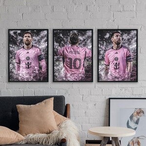 May include: Three framed prints of a soccer player wearing a pink jersey with the number 10 and the name "Messi" on the back. The player is surrounded by a white and gray abstract design.