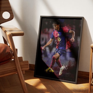 May include: A framed print of a soccer player in a red and blue jersey dribbling a soccer ball. The player is in mid-stride with a determined expression on their face. The background is a blurred image of a soccer field.