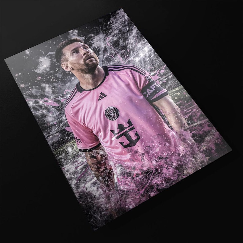 May include: A professional soccer player wearing a pink jersey with black accents and the text "CAPTAIN" on the sleeve. The jersey has a black and white crest with a crown and an anchor. The player is standing on a field with a pink and white background.