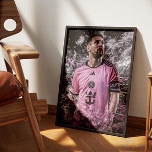 May include: A pink soccer jersey with black accents and the text "CAPT" on the sleeve. The jersey has a white crown and a ship's anchor logo. The player is wearing a black armband.