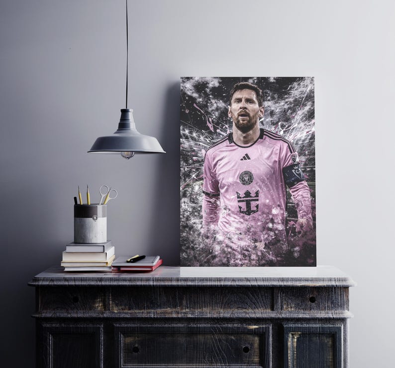 May include: A pink soccer jersey with black accents and a team logo. The jersey has a white trim around the collar and sleeves. The player is wearing the jersey and has a serious expression on his face.