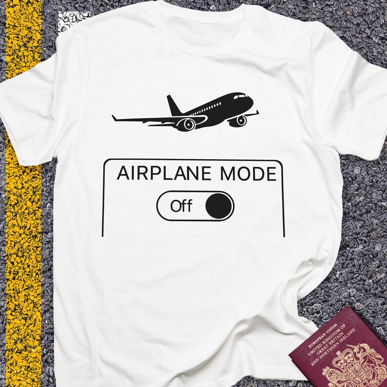 May include: White t-shirt with a black graphic of an airplane above a rectangle with the words "AIRPLANE MODE" and an "Off" switch. The shirt is made of a soft material.