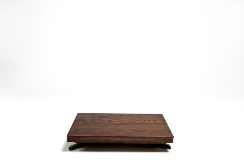 May include: A dark brown wooden coffee table with a rectangular top and a simple, modern design.