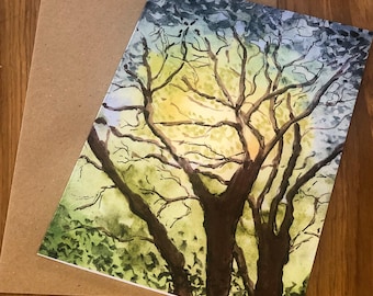 May include: Watercolor painting of a tree silhouetted against a yellow and green sky. The tree's dark brown branches reach upwards, with green foliage at the bottom. A blank, brown card is next to the painting.