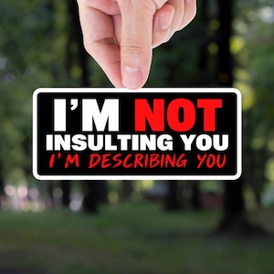 May include: A rectangular sticker with a black background and white border. The text reads I'M NOT in white, INSULTING YOU in red, and I'M DESCRIBING YOU in red below. The sticker has rounded corners and a clean, bold sans-serif font throughout.