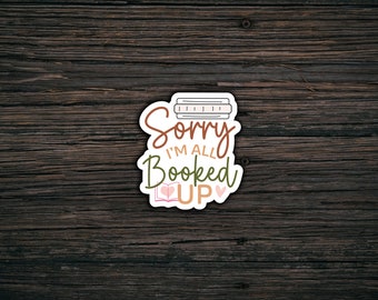 May include: A sticker with a stack of books and the text "Sorry I'm all Booked Up" with two pink hearts.