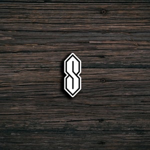May include: White stylized letter S on a dark brown wooden background.