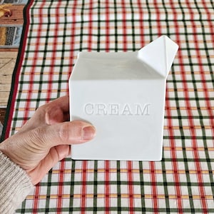 Onze witte, witte, keramische roomkan in de vorm van een eenvoudig wit melkpak