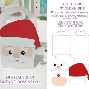 Pode incluir: Uma caixa de presente de papel branco do Papai Noel com chapéu e barba vermelhos. A caixa tem uma alça e é decorada com um rosto de Papai Noel. As dimensões são 9 cm de largura, 2,5 cm de profundidade e 15,5 cm de altura. O texto diz "DOWNLOAD INSTANTÂNEO DE ARQUIVOS DIGITAIS".