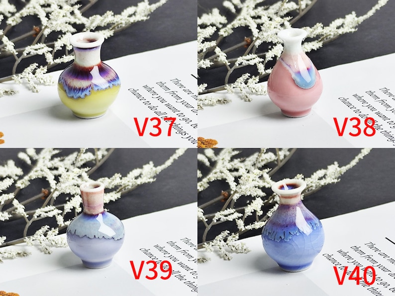 Op de afbeelding: Vier miniatuur keramische vazen met de labels V31, V38, V39 en V40. V31 is geel en paars, V38 is roze en wit, V39 is lichtblauw en wit, en V40 is blauw en paars met een craquel&eacute; effect. Elke vaas heeft een smalle hals en een ronde vorm.