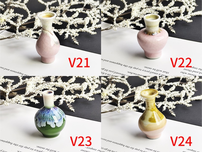 May include: Four miniature ceramic vases labeled V21, V22, V23, and V24. V21 is a tall pink vase, V22 is a rounded pink vase, V23 features green and blue glaze, and V24 is a yellow and pink vase. Each piece has a narrow neck and a flared rim.