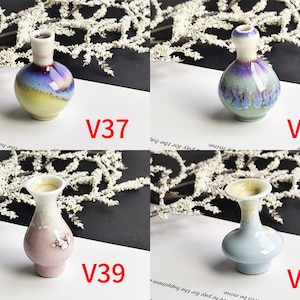 May include: Four small ceramic vases labeled V37, V38, V39, and V40. V37 has a yellow base and purple neck. V38 is round with a blue and purple glaze. V39 is pink with a flared rim. V40 is light blue with a wide, flared opening and smooth finish.