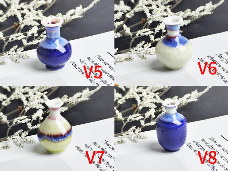 Op de afbeelding: Vier miniatuur keramische vazen gelabeld V5, V6, V7 en V8. V5 en V8 zijn diepblauw met witte randen. V6 is cr&egrave;me met een blauwe hals. V7 heeft een cr&egrave;mekleurige basis, een blauw en paars middengedeelte en een witte rand.
