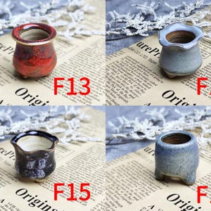 May include: Four small ceramic pots in various colors: red, blue, and dark blue. Each pot has a unique shape and design, with a textured finish. The pots are labeled with the numbers F13, F14, F15, and F16. These are miniature planters.