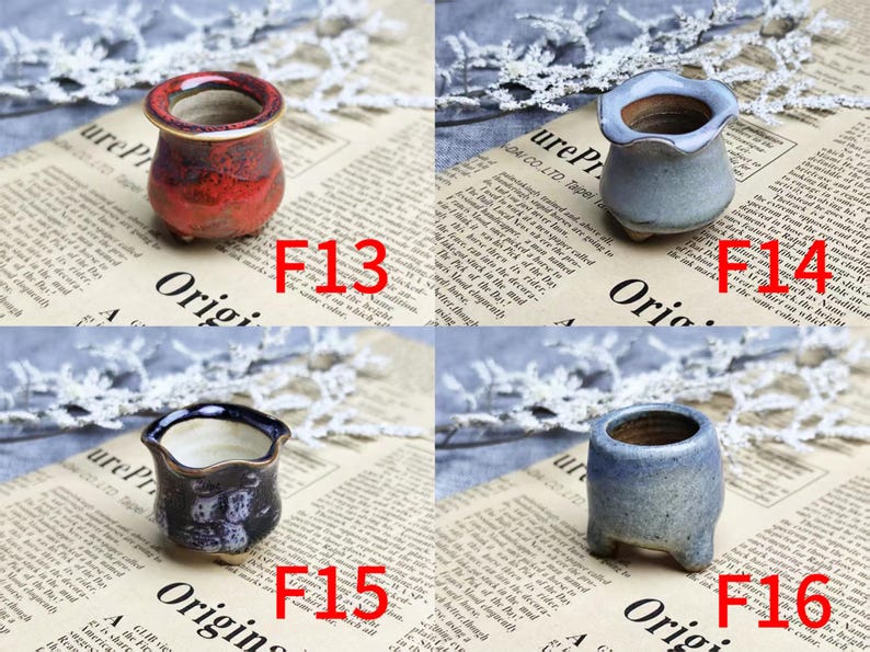 May include: Four small ceramic pots in various colors: red, blue, and dark blue. Each pot has a unique shape and design, with a textured finish. The pots are labeled with the numbers F13, F14, F15, and F16. These are miniature planters.