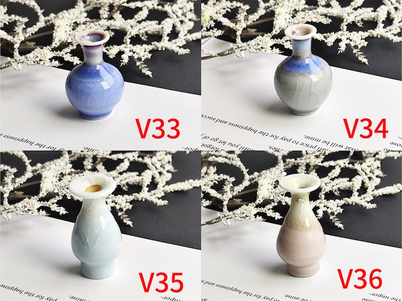 May include: Four small ceramic vases labeled V33, V34, V35, and V36. V33 is blue with a crackle glaze. V34 is gray and blue with a crackle glaze. V35 is light blue with a crackle glaze. V36 is light pink and cream with a crackle glaze.