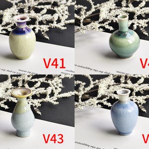 May include: Four small ceramic vases labeled V41, V42, V43, and V44. V41 is cream with a blue rim. V42 is sage green with a floral pattern. V43 has a flared rim and light blue base. V44 is a light blue vase with a crackle glaze finish.