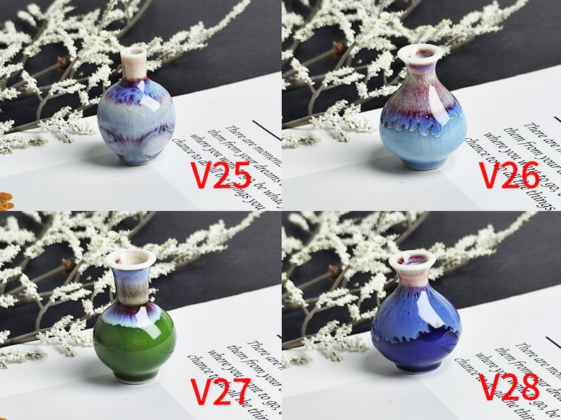 Op de afbeelding: Vier miniatuur keramische vazen gelabeld V25, V26, V27 en V28. V25 is lichtblauw met paarse druppels. V26 is lichtblauw met een paarse en witte hals. V27 heeft een groene basis en een blauw-witte hals. V28 is donkerblauw met een witte hals.