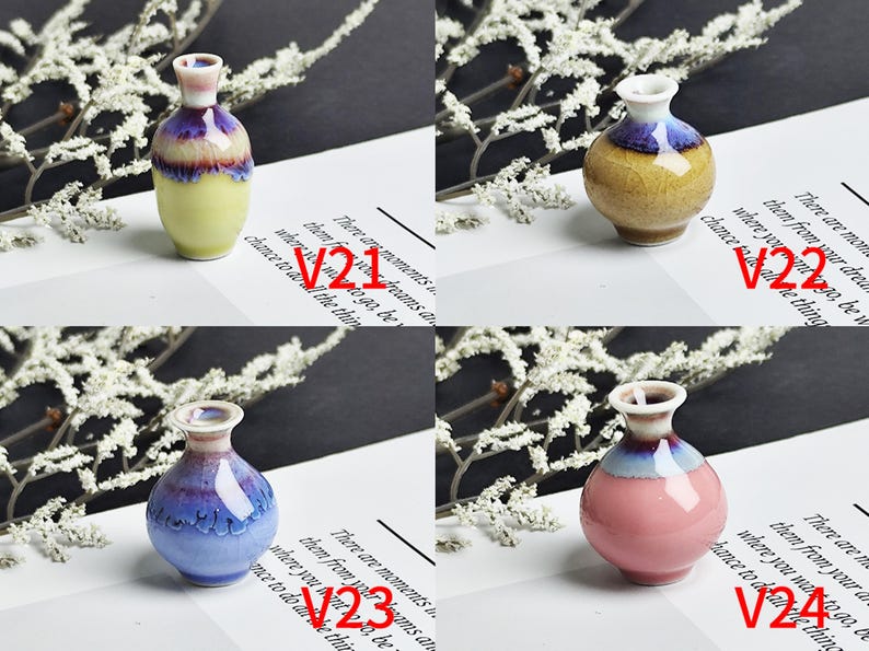 Op de afbeelding: Vier miniatuur keramische vazen gelabeld V21, V22, V23 en V24. V21 is geel met een paarse rand. V22 is beige met een blauwe rand. V23 is blauw met een donkerblauwe rand. V24 is roze met een blauwe rand. Elke vaas heeft een glanzende afwerking.