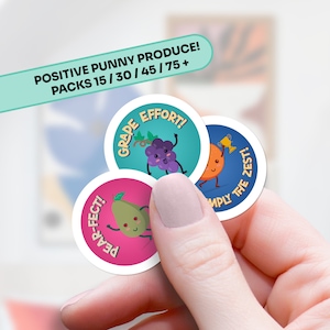 May include: Three round stickers with colorful backgrounds and cartoon fruit characters. The stickers have positive messages: "Grape Effort!" with a purple grape, "Pear-fect!" with a green pear, and "Simply the Zest!" with an orange.