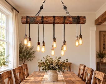 May include: A rectangular wooden beam chandelier suspended by black chains, featuring ten hanging black cords with exposed Edison-style light bulbs. The beam has dark metal brackets at each end and is positioned above a long wooden dining table.