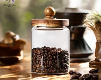 May include: A glass jar with a wooden lid and a wooden knob. The jar is filled with coffee beans. The jar is sitting on a wooden table.