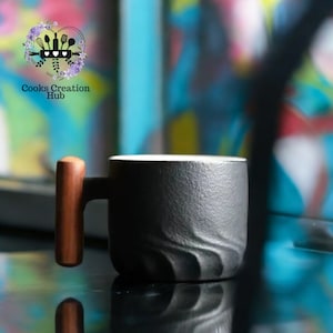 May include: A black ceramic mug with a textured, wavy design and a wooden handle. The mug is sitting on a reflective surface.