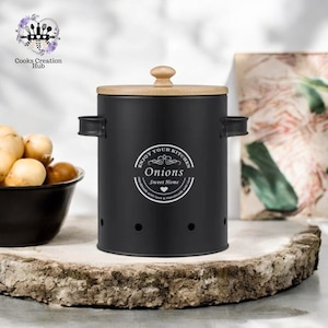 Pode incluir: Recipiente de armazenamento de cebola de metal preto com tampa de madeira. O recipiente tem um rótulo branco que diz "Enjoy Your Kitchen Onions Sweet Home Handmade with love & handmade with love".