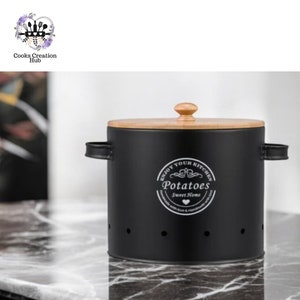 Puede incluir: Contenedor de metal negro con tapa de madera y una inscripción blanca que dice "Enjoy Your Kitchen Potatoes Sweet Home".