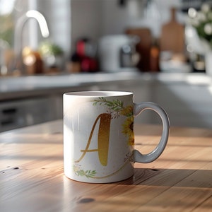 Pu&ograve; includere: Tazza in ceramica bianca con una lettera A dorata e un design floreale con girasoli e verde.