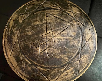 May include: A round, antique-style shield with a distressed bronze finish. The shield features etched geometric patterns and a central symbol. The overall design evokes a sense of history and fantasy.