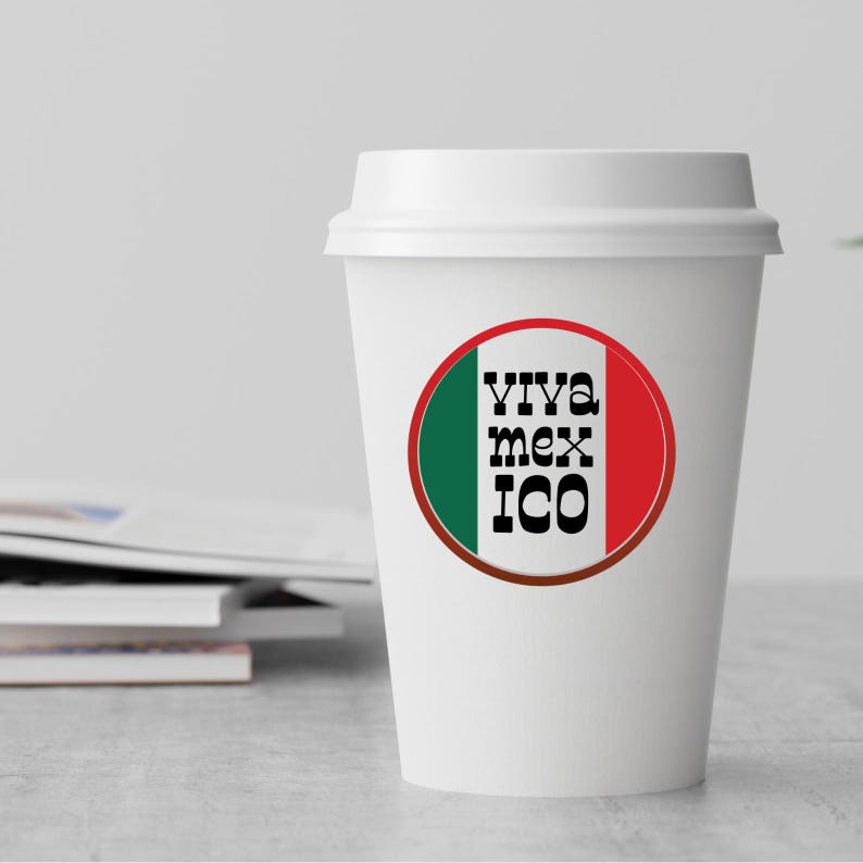 May include: White to-go coffee cup with a red, white, and green circle sticker that says "Viva Mexico" in black text.