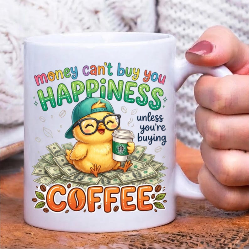 Pode incluir: Uma caneca de cer&acirc;mica branca com um pintinho amarelo usando um bon&eacute; verde e &oacute;culos pretos, segurando um copo de caf&eacute; sobre uma pilha de notas. O texto diz: money can't buy you HAPPINESS unless you're buying COFFEE.