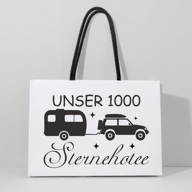 May include: White tote bag with black rope handles. The bag features a black graphic of a caravan and SUV, with the text "UNSER 1000 Sternehotel" in black. The design includes star accents, ideal for travel lovers.