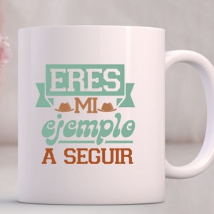 Puede incluir: Taza de cer&aacute;mica blanca con un dise&ntilde;o en verde azulado y marr&oacute;n. El texto en la taza dice "ERES MI ejemplo A SEGUIR".
