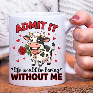 Pode incluir: Uma caneca de cer&acirc;mica branca com uma vaca de desenho animado com manchas pretas, usando um sino e segurando uma rosa vermelha na boca. O texto diz ADMIT IT e life would be boring WITHOUT ME, rodeado por pequenos cora&ccedil;&otilde;es vermelhos e estrelas.