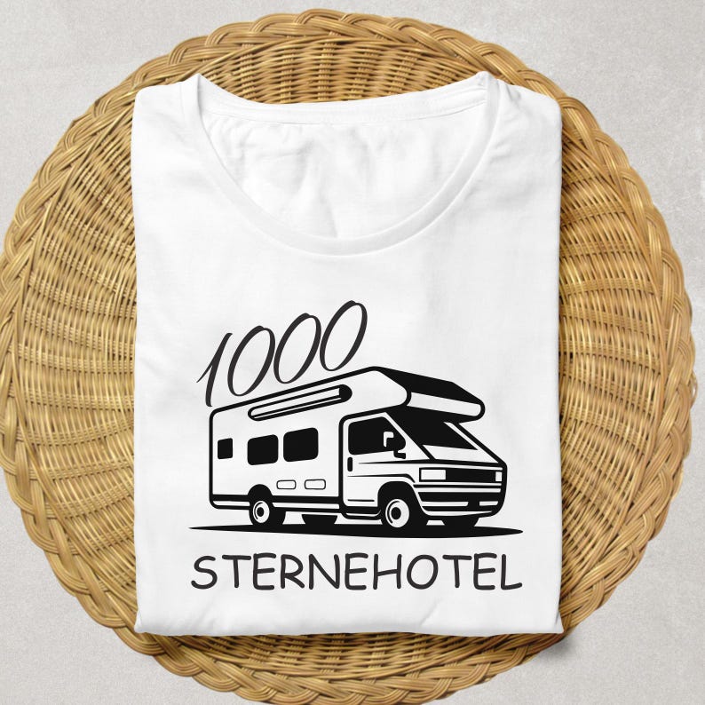 May include: White t-shirt featuring a black camper van graphic and the words "1000 STERNEHOTEL". The shirt is folded on a woven, circular, light brown surface.